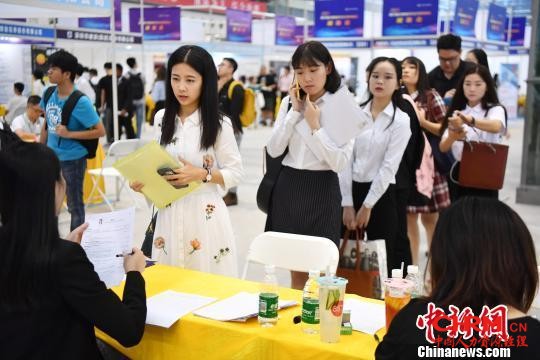  图为毕业生求职者排队递简历、面试。 陈文 摄