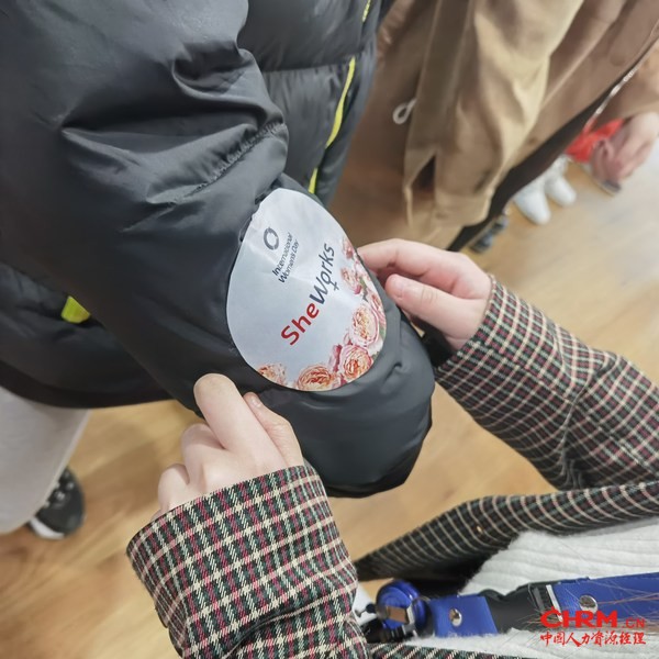 SheWorks伊职参与女性代表和索迪斯工作伙伴志愿者互相为对方贴上印有SheWorks标识的贴纸