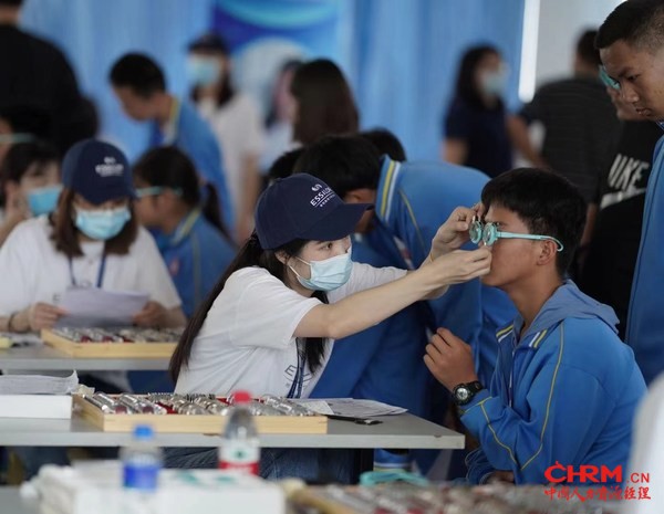 志愿者为孩子进行插片验光 志愿者为孩子进行插片验光