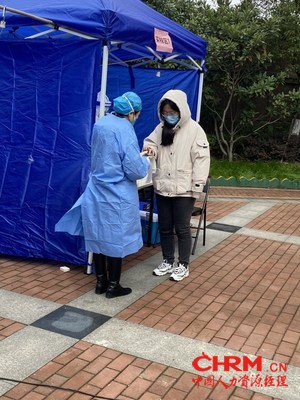 成功人力组织的志愿者协助登记、测温