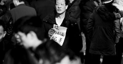 人才市场内，男子拿着招聘单子，露出无奈的神情。