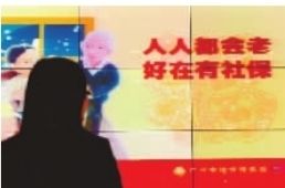 一广州市民在观看社会养老保险的宣传画。 一广州市民在观看社会养老保险的宣传画。
