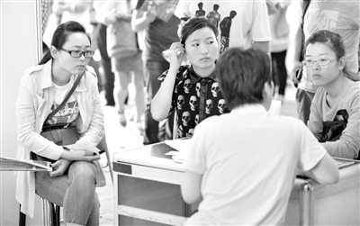 5月18日，农展馆人才招聘会上，求职者在招聘展台咨询。新京报记者 薛珺 摄