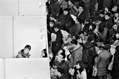 今年1月6日，国展，一招人单位摊位前，应聘者在询问情况。当天，国展举行研究生专场招聘会。新京报记者 王嘉宁 摄
